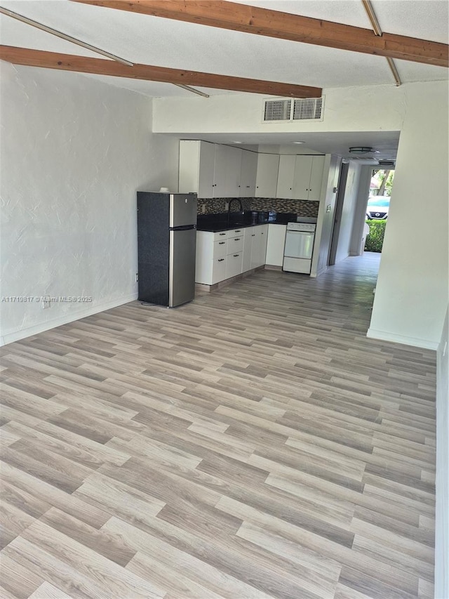 kitchen featuring dishwashing machine, stainless steel fridge, tasteful backsplash, and light hardwood / wood-style floors