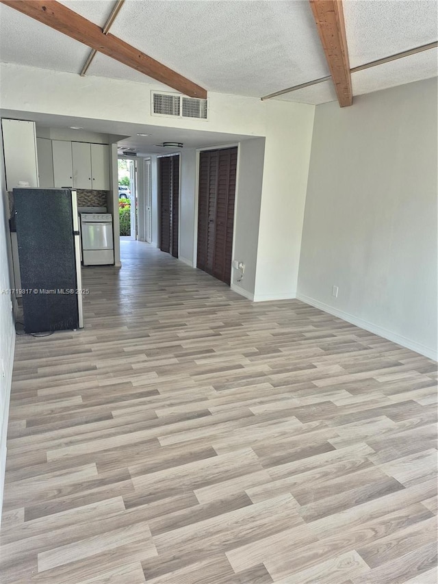 kitchen with gray cabinetry, light hardwood / wood-style flooring, a textured ceiling, beamed ceiling, and dishwashing machine