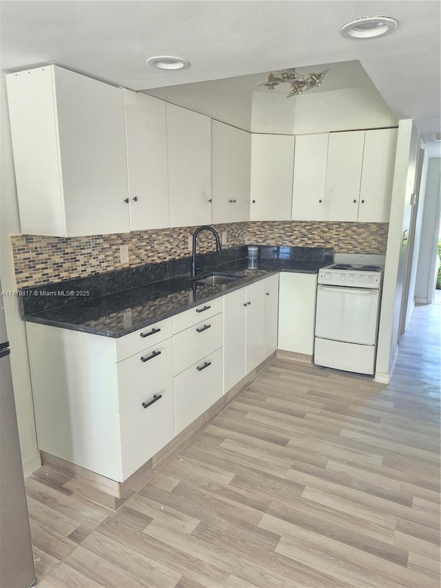 kitchen with white cabinets, white range oven, light wood-type flooring, and sink