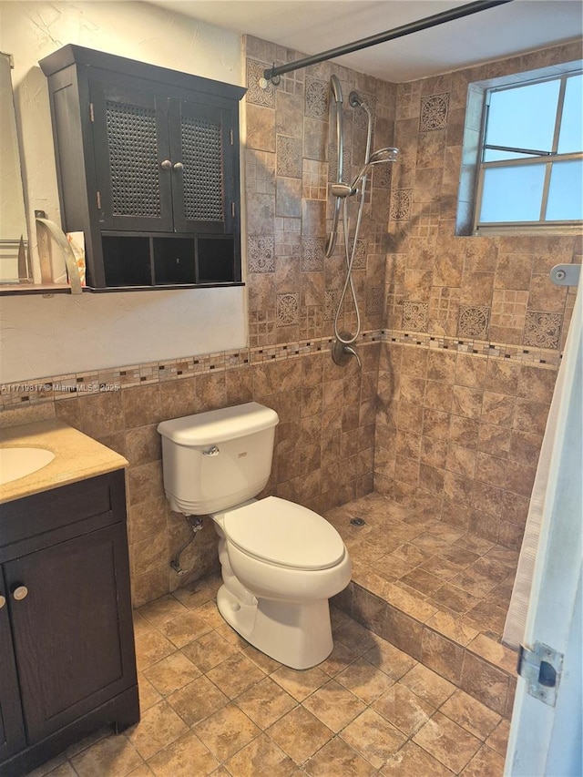 bathroom featuring tiled shower, vanity, and toilet