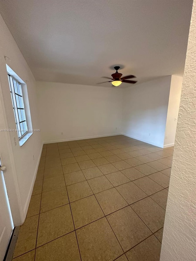 tiled empty room with ceiling fan