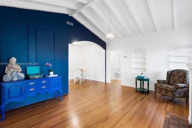 sitting room with lofted ceiling with beams, hardwood / wood-style flooring, and built in features