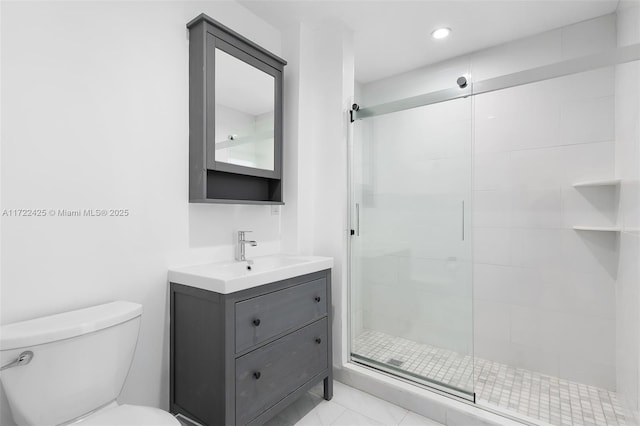 bathroom featuring vanity, toilet, and a shower with door