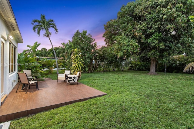 yard at dusk featuring a patio