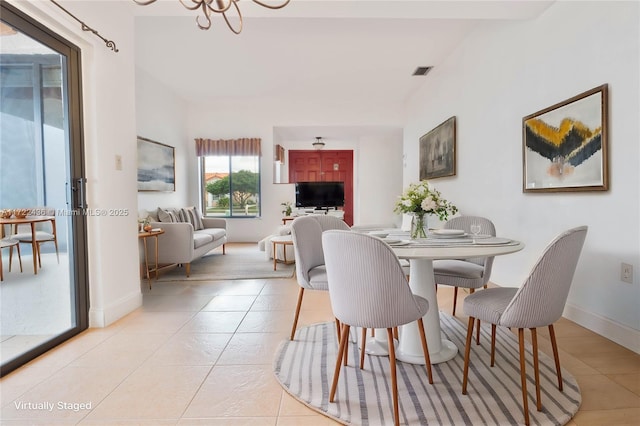 tiled dining room with a notable chandelier