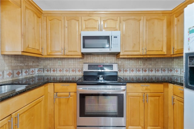 kitchen with backsplash, sink, dark stone counters, and stainless steel range with electric stovetop