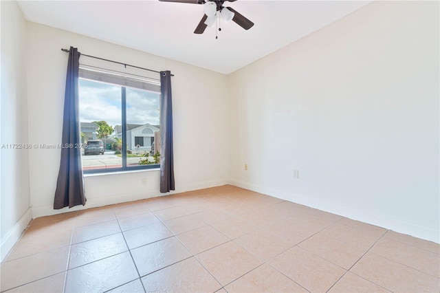 tiled spare room featuring ceiling fan