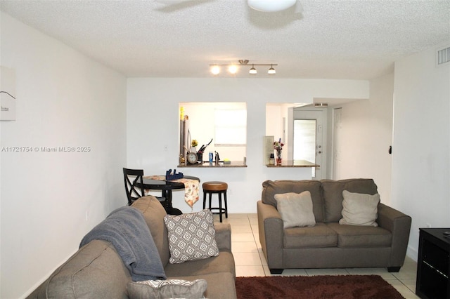 tiled living room featuring a textured ceiling