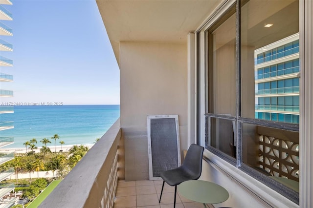 balcony featuring a water view and a beach view