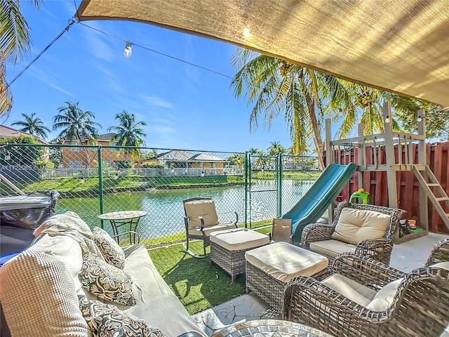 view of patio featuring a playground, an outdoor hangout area, and a water view