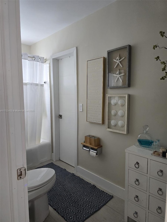 bathroom featuring tile patterned flooring, toilet, and shower / tub combo with curtain