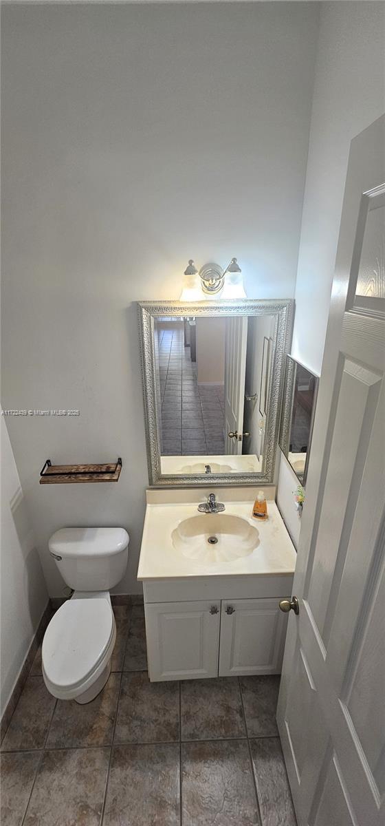 bathroom featuring tile patterned floors, vanity, and toilet