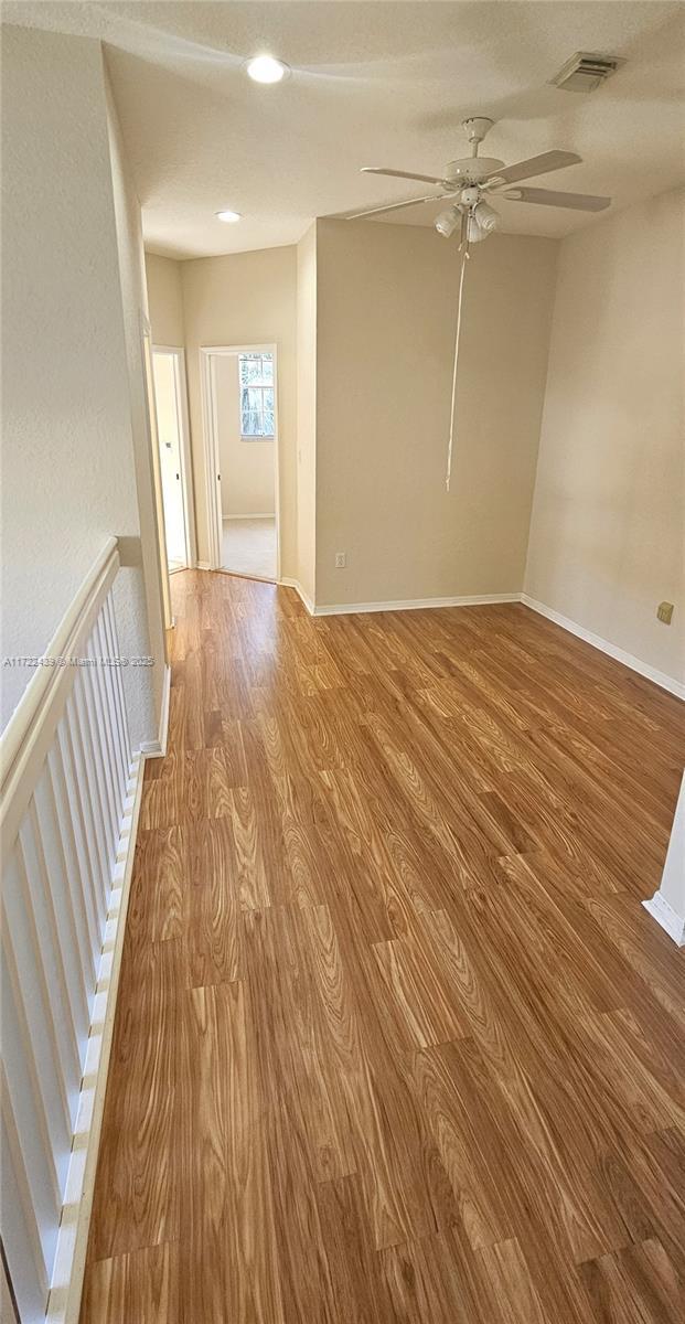 spare room featuring ceiling fan and light hardwood / wood-style flooring