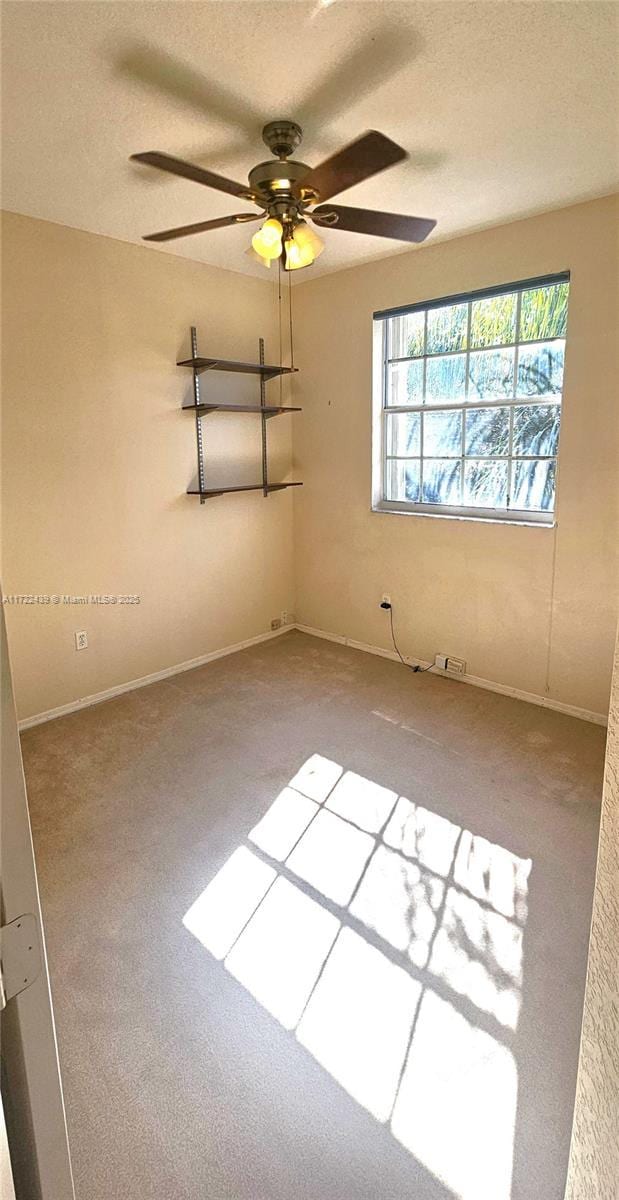 carpeted empty room featuring a textured ceiling and ceiling fan