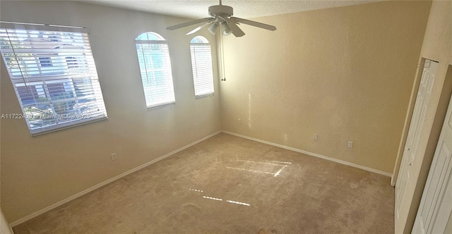 carpeted empty room featuring a textured ceiling and ceiling fan