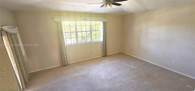 spare room with a textured ceiling, carpet floors, and ceiling fan