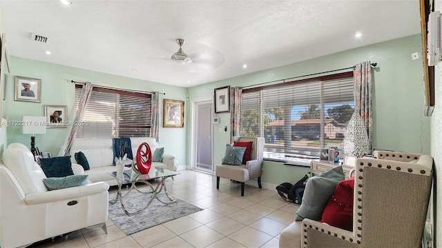 tiled living room with ceiling fan and a textured ceiling