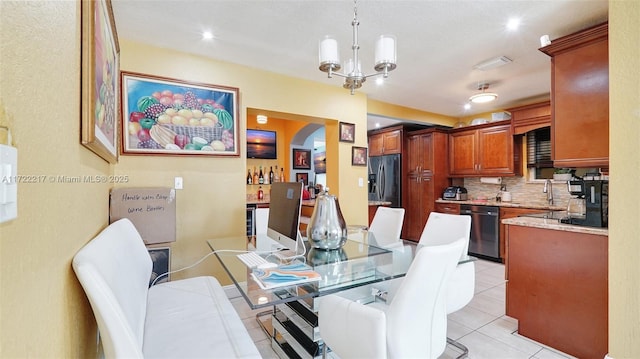 tiled dining space with sink and an inviting chandelier