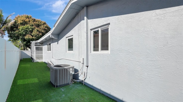 view of home's exterior with a yard and central AC