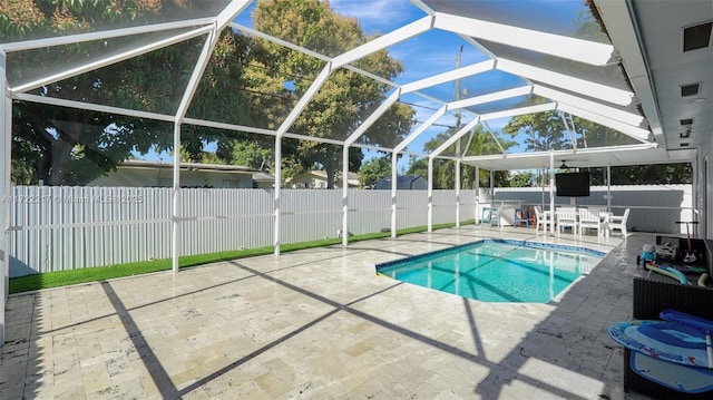 view of swimming pool featuring glass enclosure and a patio