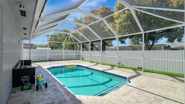 view of pool with glass enclosure and a patio area