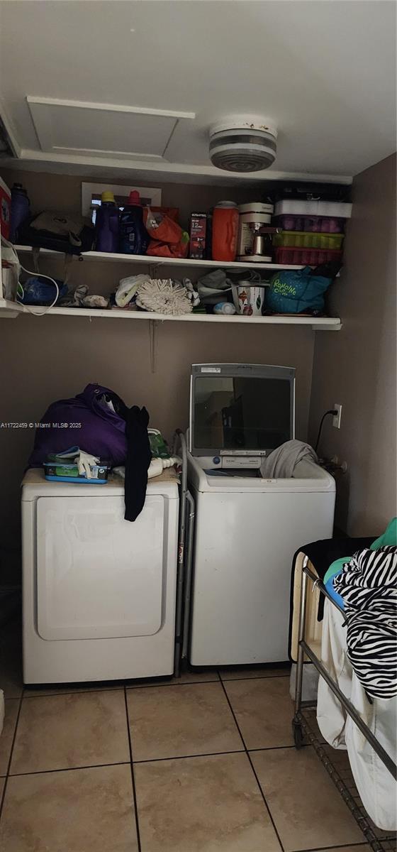 washroom featuring washing machine and dryer and tile patterned flooring