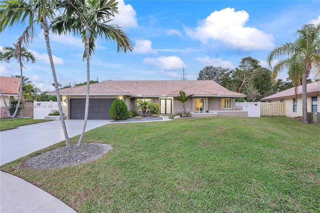 view of front of home with a garage, a front yard, and central AC