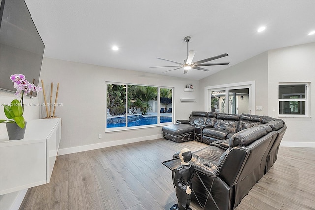 living room with light hardwood / wood-style floors, ceiling fan, and lofted ceiling