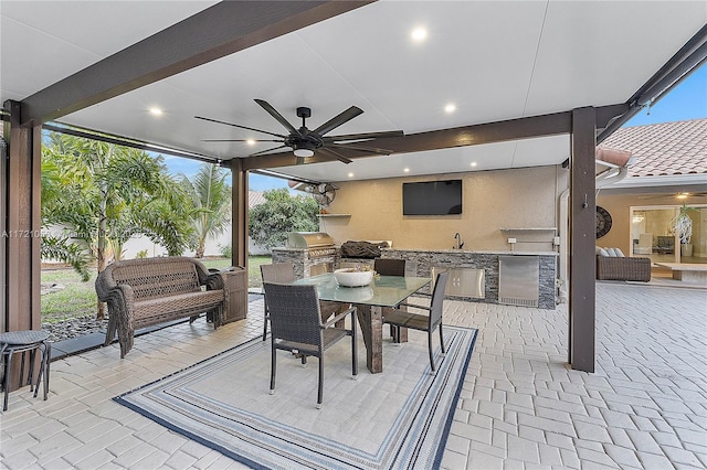 view of patio with ceiling fan, area for grilling, sink, and grilling area