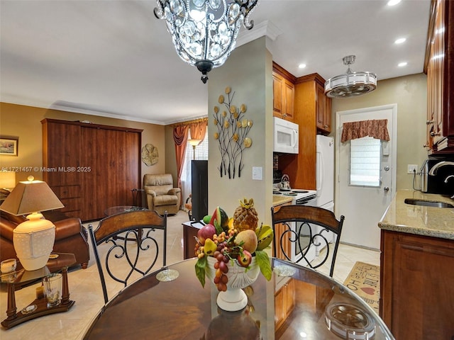 tiled dining room featuring sink, an inviting chandelier, and ornamental molding