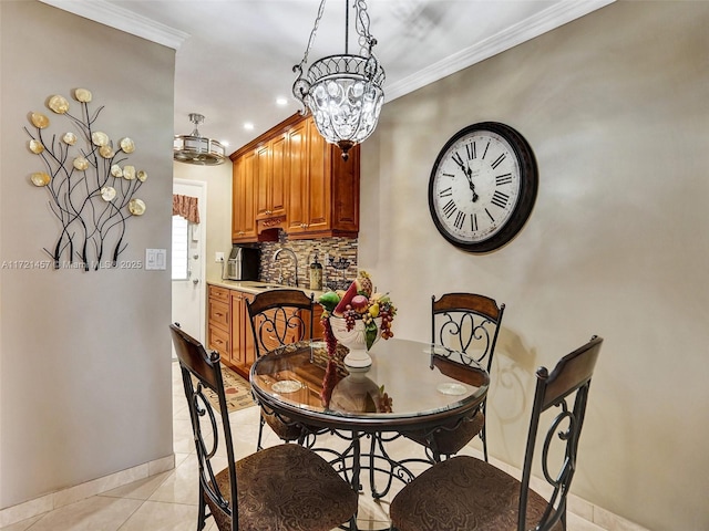 tiled dining space featuring a notable chandelier, ornamental molding, and sink