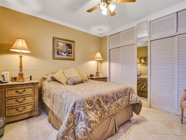 bedroom with ceiling fan, light tile patterned floors, two closets, and ornamental molding