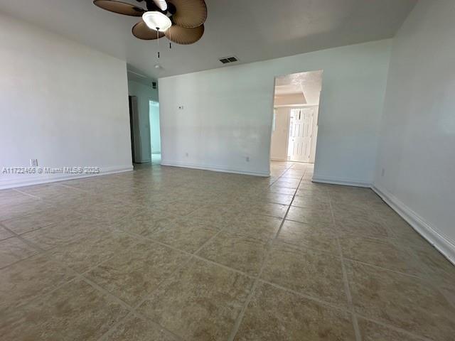 tiled spare room with ceiling fan