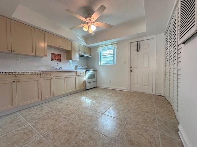 kitchen with white electric range, a tray ceiling, ceiling fan, and sink