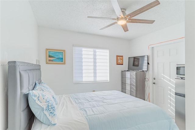 bedroom with ceiling fan and a textured ceiling