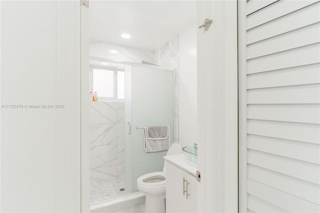 bathroom featuring vanity, toilet, and an enclosed shower