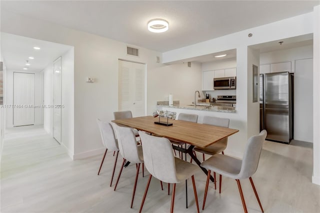 dining space featuring light hardwood / wood-style floors and sink