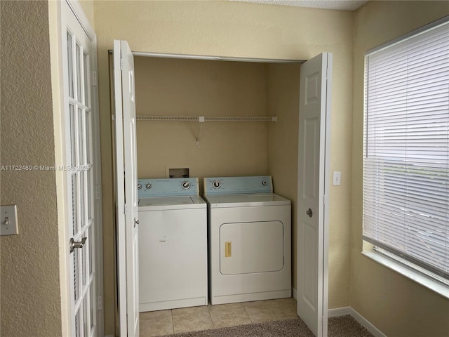 washroom featuring light tile patterned flooring and washing machine and clothes dryer