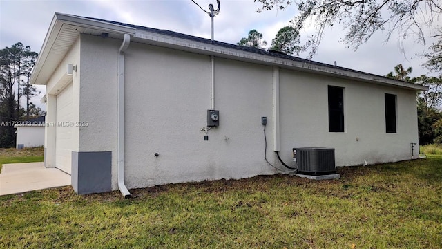 view of side of property featuring central air condition unit and a yard