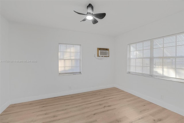 unfurnished room featuring a wealth of natural light, ceiling fan, light hardwood / wood-style flooring, and a wall mounted air conditioner