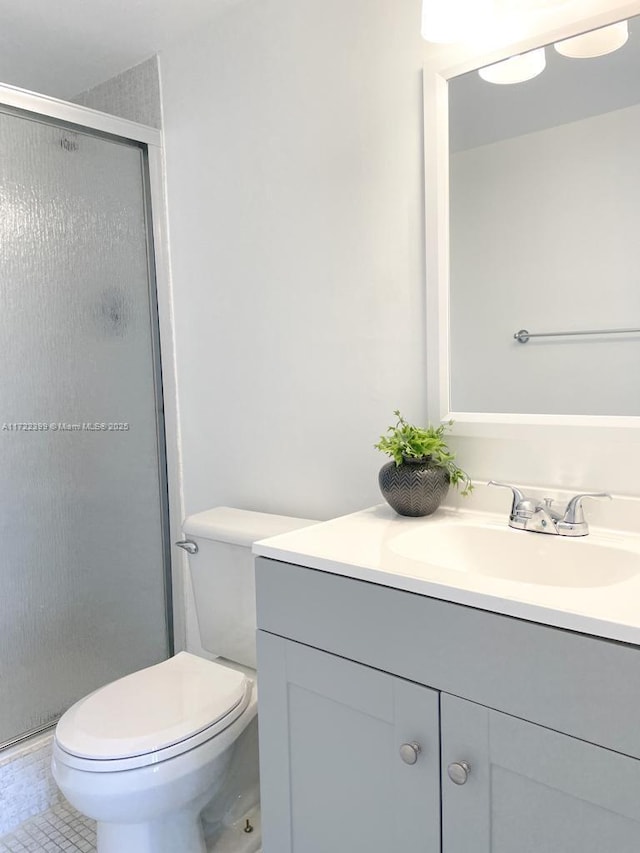 bathroom featuring walk in shower, tile patterned floors, vanity, and toilet