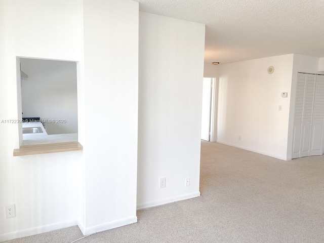 carpeted spare room featuring a textured ceiling