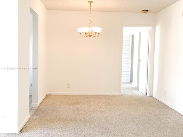 unfurnished room featuring carpet floors and a chandelier