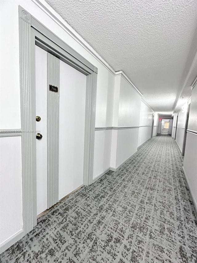 hall with carpet and a textured ceiling