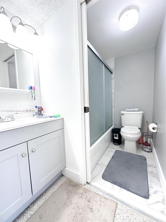 full bathroom with vanity, bath / shower combo with glass door, a textured ceiling, and toilet