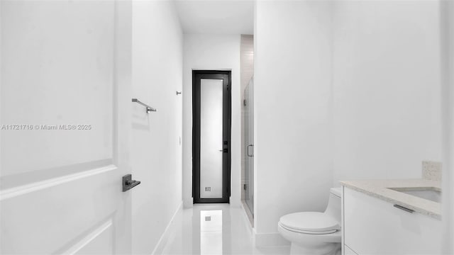 bathroom featuring tile patterned flooring, vanity, toilet, and walk in shower