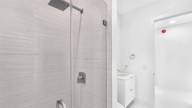 bathroom featuring tiled shower and vanity