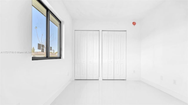 unfurnished bedroom with two closets