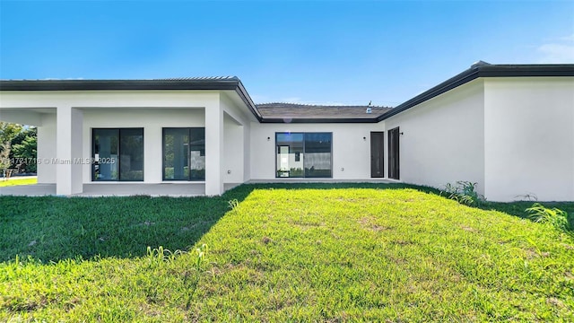 rear view of property with a yard