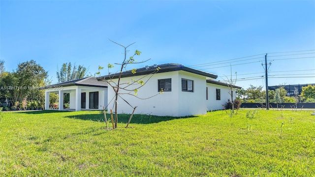 rear view of house featuring a lawn